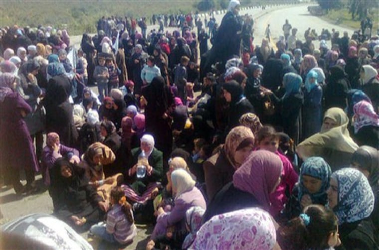 Syrian women hold an anti-government demonstration in Banias, Syria, on Wednesday, April 13. Thousands of Syrian women and children holding white flags and olive branches blocked a main coastal highway Wednesday, demanding authorities release people detained during a crackdown on opponents of the regime, witnesses said. The crowd — unusual because it was dominated by women and young children —demanded the release of hundreds of men who have been rounded up in the northeastern villages of Bayda and Beit Jnad and surrounding areas in recent days. 